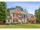 Beautiful two-story brick home with a well-maintained lawn and classic architectural details at 205 Devon Downs Pl, Alpharetta, GA 30005