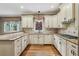 Kitchen showcasing granite countertops, white cabinets, hardwood floors, and stainless steel appliances at 205 Devon Downs Pl, Alpharetta, GA 30005