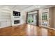 Spacious living room features hardwood floors, fireplace with built-in shelving, coffered ceilings, and glass doors at 205 Devon Downs Pl, Alpharetta, GA 30005