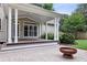 Inviting covered patio featuring a stone fire pit, providing an ideal outdoor relaxation space at 205 Devon Downs Pl, Alpharetta, GA 30005