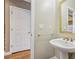 Powder room showcasing pedestal sink with gold faucet and mirror with gold frame at 205 Devon Downs Pl, Alpharetta, GA 30005