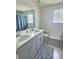 Bathroom with double sink vanity, grey cabinets, striped rugs and tile flooring at 283 Wells Cir, Canton, GA 30114