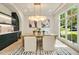 Bright dining room with a modern chandelier, stylish built-in cabinets, and large windows overlooking the landscape at 3006 Skyland Ne Dr, Brookhaven, GA 30319