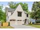 Beautiful home with a white brick facade, two-car garage, arched entryway, and mature trees at 3006 Skyland Ne Dr, Brookhaven, GA 30319