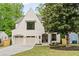 Charming two-story home features a white brick facade, arched entryway, and a two-car garage at 3006 Skyland Ne Dr, Brookhaven, GA 30319