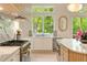 A gourmet kitchen features white cabinets, marble countertops, stainless appliances and a large window with green outdoor views at 3006 Skyland Ne Dr, Brookhaven, GA 30319