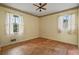 Empty bedroom featuring yellow walls, two windows and hardwood floors at 34 Duke Dr, Lawrenceville, GA 30046