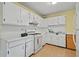 Efficient kitchen with white cabinets, appliances, and tile flooring for easy maintenance at 34 Duke Dr, Lawrenceville, GA 30046