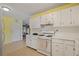 Well-lit kitchen with white appliances, cabinets, and a view of the adjacent dining area at 34 Duke Dr, Lawrenceville, GA 30046