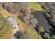 Aerial view of a house with a pond, showcasing its private, wooded surroundings at 574 Oak Grove Rd, Temple, GA 30179