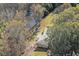 A birds-eye view of a brick home that is located next to a tranquil pond and surrounded by trees at 574 Oak Grove Rd, Temple, GA 30179