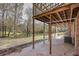 Back patio area with an elevated deck overhead and a scenic view of the pond in the back yard at 574 Oak Grove Rd, Temple, GA 30179