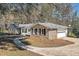 A well-maintained brick home featuring a two-car garage and manicured landscaping at 574 Oak Grove Rd, Temple, GA 30179