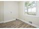Finished room with wood-look floors, fresh paint, and a bright window that gives a view of the surrounding landscape at 574 Oak Grove Rd, Temple, GA 30179