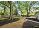 Lush backyard with mature trees, a fire pit, and gravel pathways, creating a tranquil outdoor retreat at 957 Sharon Se Cir, Smyrna, GA 30080