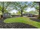 Expansive backyard featuring mature trees, a fire pit, and a charming outbuilding, perfect for relaxation at 957 Sharon Se Cir, Smyrna, GA 30080
