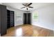 Bright bedroom with hardwood floors, ceiling fan, and built-in bookshelves flanking the windows at 957 Sharon Se Cir, Smyrna, GA 30080
