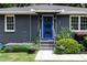 Close up of a blue front door on gray home with white trim, flanked by windows and landscaped garden beds at 957 Sharon Se Cir, Smyrna, GA 30080