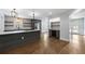 Stylish kitchen with a gray island, marble countertops, floating shelves, stainless steel appliances, and hardwood floors at 957 Sharon Se Cir, Smyrna, GA 30080