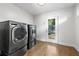 A modern laundry room with new front-load washer, dryer, and an exterior door at 957 Sharon Se Cir, Smyrna, GA 30080