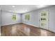 Bright living room with hardwood floors, white trim, a glass paneled door, and natural light from two windows at 957 Sharon Se Cir, Smyrna, GA 30080