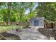 Outdoor shed with blue doors, small deck, and gravel landscaping in backyard at 957 Sharon Se Cir, Smyrna, GA 30080