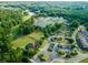 Aerial photo showcasing community tennis courts, parking, surrounding homes, and lush trees at 147 Gold Bridge Xing, Canton, GA 30114