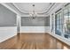 Formal dining room featuring hardwood floors, wainscoting, tray ceiling, and large windows for natural light at 147 Gold Bridge Xing, Canton, GA 30114