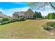 Traditional home featuring a well-kept lawn, stone details, and mature trees in a landscaped front yard at 147 Gold Bridge Xing, Canton, GA 30114