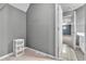Hallway view leads to bonus room, showcasing access to tiled bathroom with sink vanity and storage at 147 Gold Bridge Xing, Canton, GA 30114