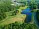 Aerial view showcasing a beautiful pond surrounded by lush green trees and grassy areas at 147 Gold Bridge Xing, Canton, GA 30114