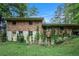 Back of house with brick and siding exterior, overgrown vegetation and satellite dish at 2214 River Rd, Ellenwood, GA 30294