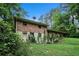 View of the back of the house from yard level with satellite dish and overgrown vegetation at 2214 River Rd, Ellenwood, GA 30294