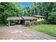 A single Gathering home with a carport in the driveway surrounded by mature trees at 2214 River Rd, Ellenwood, GA 30294