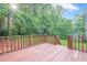 A stained-wood back deck overlooking a lush backyard with mature trees provides privacy at 2326 Westland Way, Acworth, GA 30102