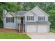 Charming home features a two-car garage and inviting front stairs, complemented by lush green landscaping at 2326 Westland Way, Acworth, GA 30102