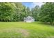 Exterior shot of a well-maintained home featuring a two-car garage and a spacious yard surrounded by trees at 2326 Westland Way, Acworth, GA 30102