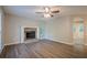 Cozy living room featuring a stone fireplace, hardwood floors, ceiling fan, and an open archway to the dining area at 2326 Westland Way, Acworth, GA 30102