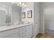 Bathroom featuring dual sinks, white cabinetry, and walk-in closet access at 286 Abbotts Crossing Cir, Conyers, GA 30094