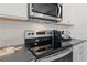 Kitchen featuring stainless steel appliances, sleek countertops, and modern backsplash at 286 Abbotts Crossing Cir, Conyers, GA 30094