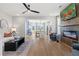 Open-concept living room with wood floors, modern fireplace, ceiling fan, and access to the kitchen at 286 Abbotts Crossing Cir, Conyers, GA 30094
