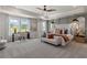 Bright main bedroom with tray ceiling, neutral décor, ceiling fan, and sitting area at 286 Abbotts Crossing Cir, Conyers, GA 30094