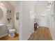Stylish half bathroom with wood floors, pedestal sink, modern fixtures, and decorative wall art at 286 Abbotts Crossing Cir, Conyers, GA 30094