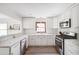 Kitchen features white cabinets, stainless steel appliances, a subway tile backsplash, and new flooring at 4527 Sims Ct, Tucker, GA 30084