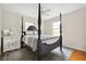 A stylish main bedroom features a dark-wood, four-poster bed and a patterned rug at 4527 Sims Ct, Tucker, GA 30084