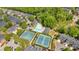 Aerial view of community featuring tennis courts and a swimming pool surrounded by lush trees at 5407 Waters Edge Trl, Roswell, GA 30075