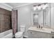 Bathroom features a vanity sink, toilet, shower with brown tile surround, and patterned shower curtain at 5407 Waters Edge Trl, Roswell, GA 30075