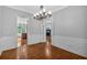 Formal dining room with hardwood floors, decorative chandelier, and views through French doors at 5407 Waters Edge Trl, Roswell, GA 30075