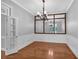 Bright formal dining room with hardwood floors, decorative chandelier, and wainscotting at 5407 Waters Edge Trl, Roswell, GA 30075