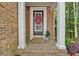 Inviting front porch with brick flooring, decorative wreath, and potted plant at 5407 Waters Edge Trl, Roswell, GA 30075